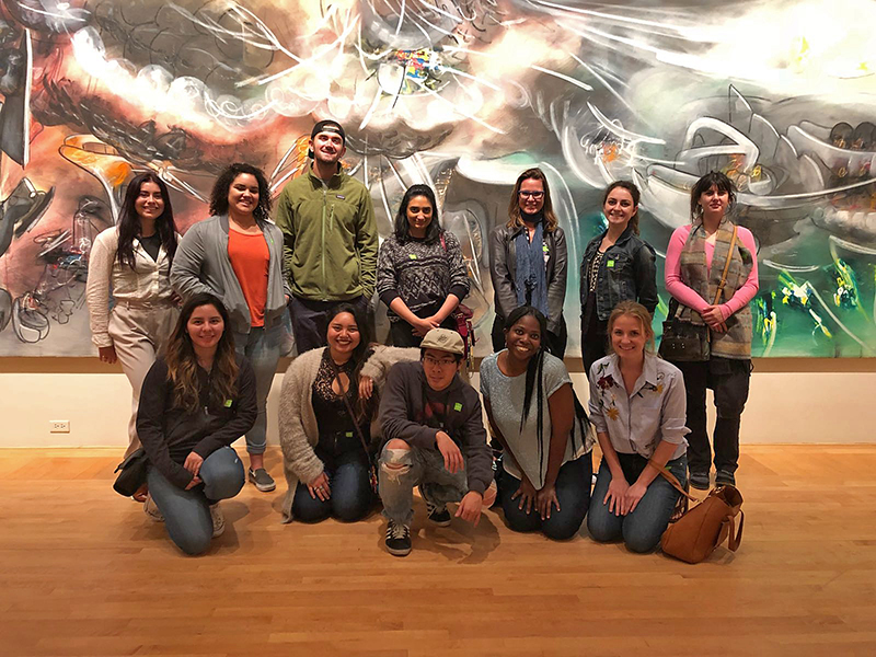 Visiting Assistant Professor Amy Buono stands with her undergratuate students in an art museum gallery.